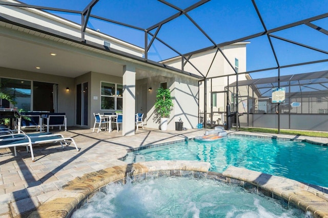 view of swimming pool featuring an in ground hot tub, a lanai, and a patio