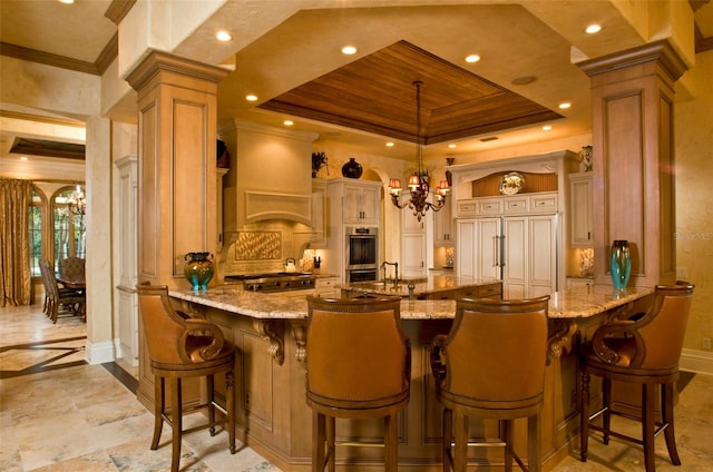 kitchen with light stone counters, kitchen peninsula, pendant lighting, and custom range hood