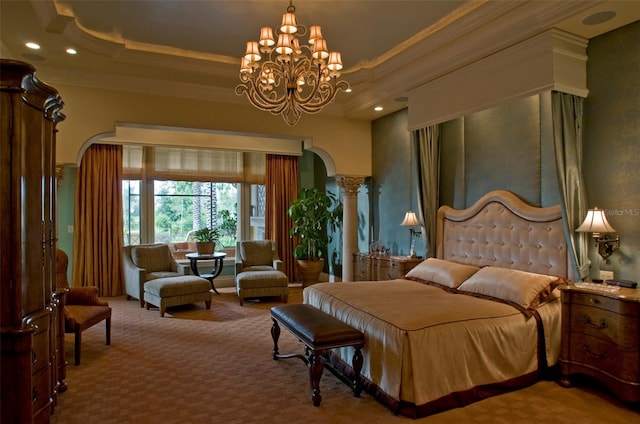 carpeted bedroom featuring ornamental molding, a notable chandelier, ornate columns, and a tray ceiling