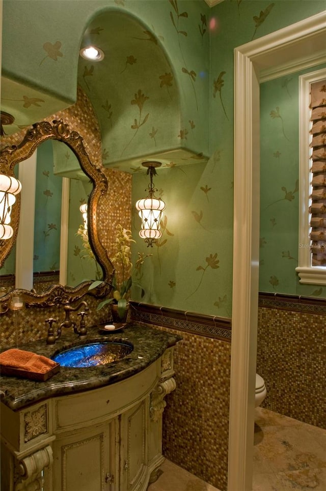 bathroom featuring tile walls, large vanity, toilet, and tile flooring