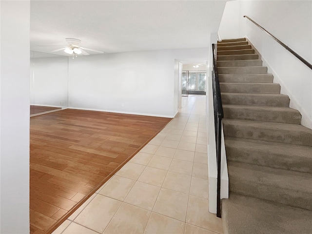 stairs with ceiling fan and light wood-type flooring