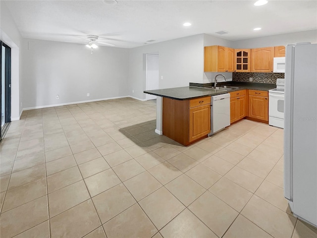 kitchen featuring kitchen peninsula, backsplash, white appliances, ceiling fan, and light tile floors