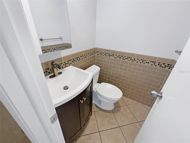 bathroom featuring tile floors, tile walls, vanity, tasteful backsplash, and toilet