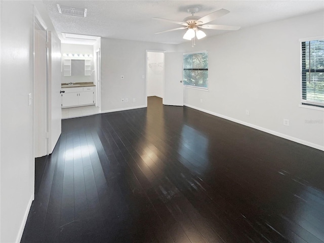 spare room with ceiling fan, a textured ceiling, and dark wood-type flooring