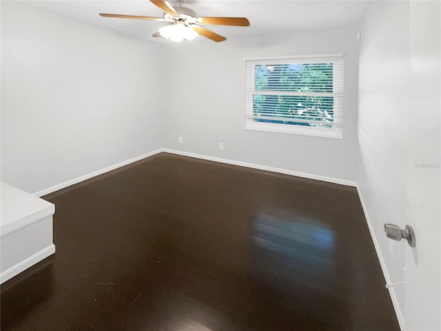 spare room featuring dark wood-type flooring and ceiling fan