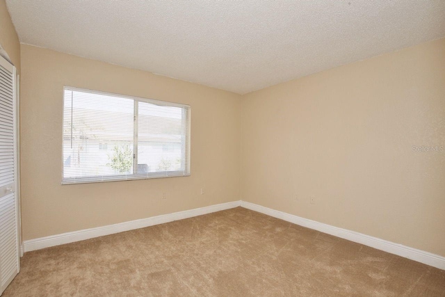 carpeted spare room with a textured ceiling