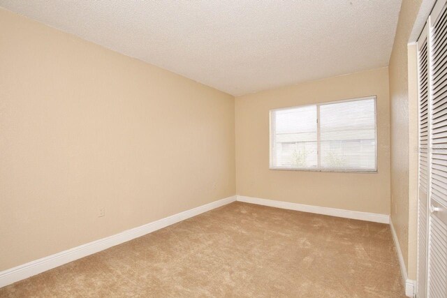 interior space with a textured ceiling and carpet flooring