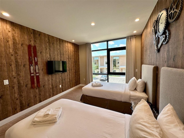 carpeted bedroom featuring wooden walls