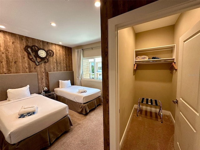 carpeted bedroom with wood walls and a closet