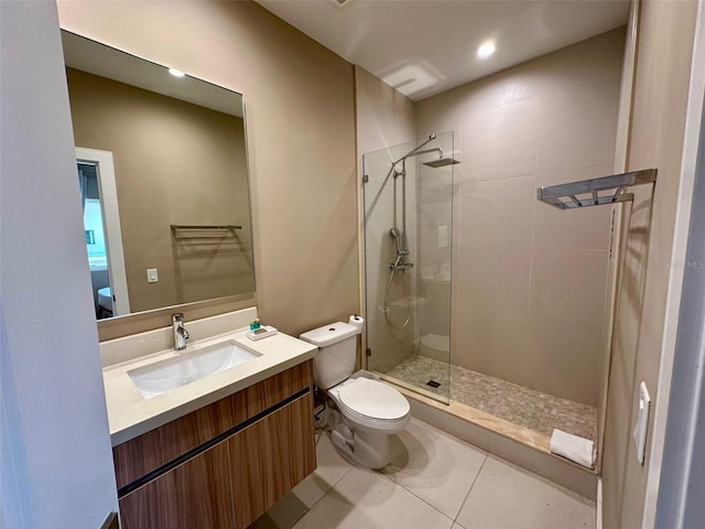 bathroom with toilet, tile floors, vanity, and a shower with door