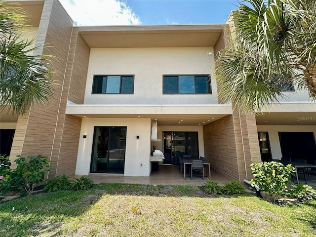 back of house featuring a patio and a lawn