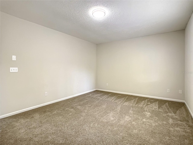 carpeted spare room with baseboards and a textured ceiling