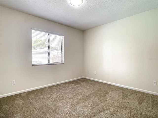 unfurnished room featuring carpet floors, a textured ceiling, and baseboards