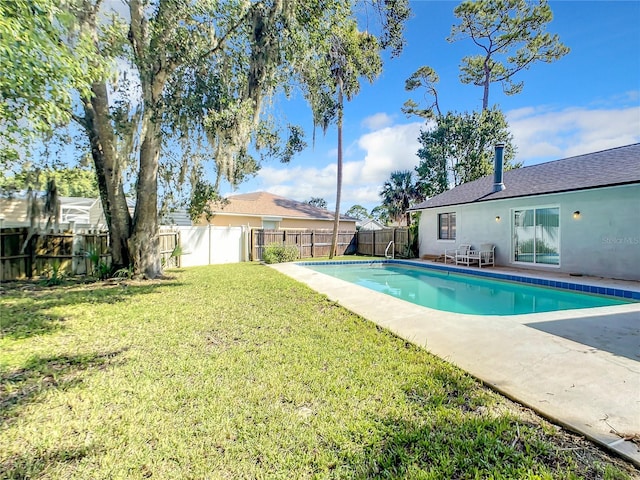 view of swimming pool with a fenced backyard, a lawn, and a fenced in pool