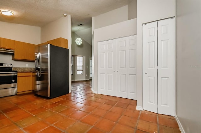 kitchen featuring high vaulted ceiling, a textured ceiling, tile flooring, and appliances with stainless steel finishes