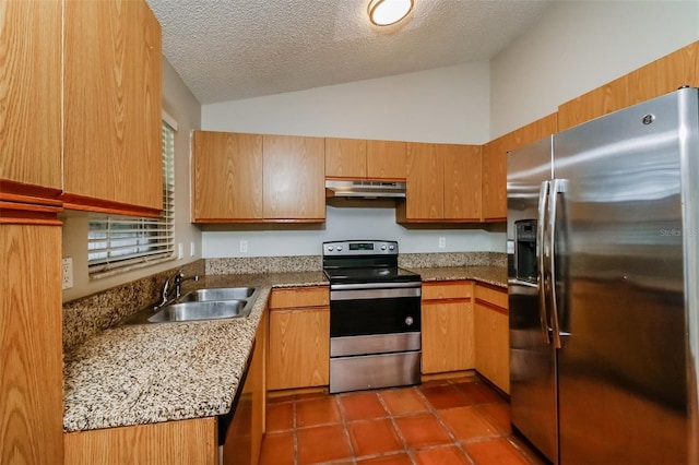 kitchen with appliances with stainless steel finishes, a textured ceiling, light stone countertops, lofted ceiling, and sink