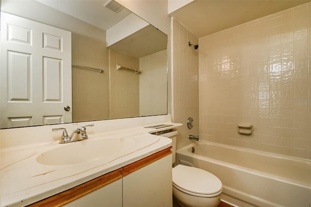 full bathroom featuring tiled shower / bath combo, toilet, and vanity with extensive cabinet space