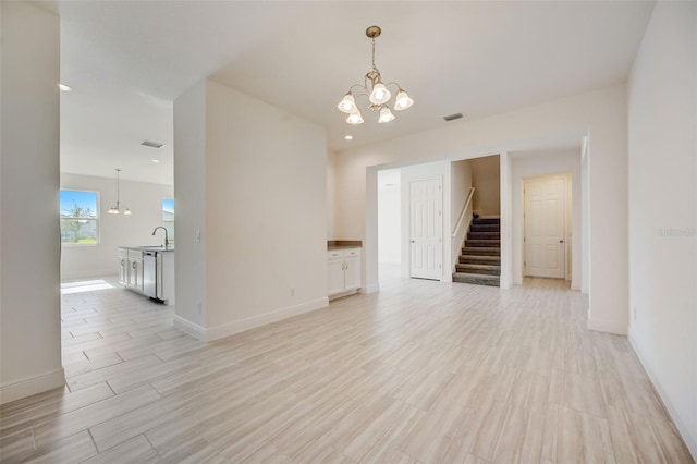 unfurnished room featuring a chandelier and sink