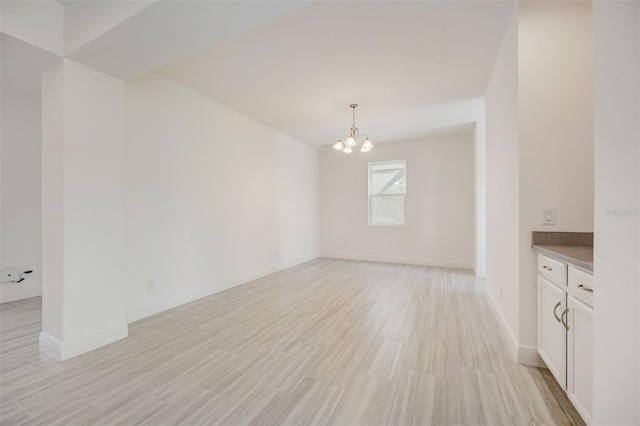 interior space with light wood-type flooring and an inviting chandelier