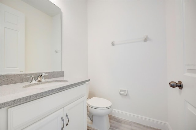 bathroom featuring hardwood / wood-style flooring, toilet, and large vanity