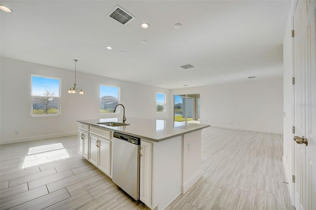 kitchen with hanging light fixtures, dishwasher, a kitchen island with sink, white cabinetry, and sink