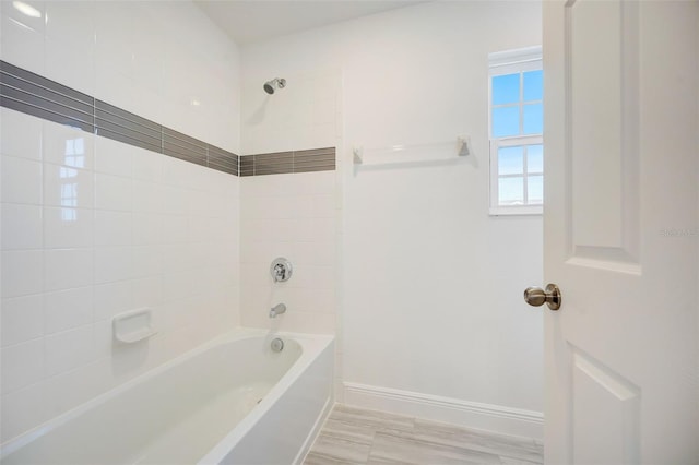 bathroom with hardwood / wood-style floors and tiled shower / bath combo