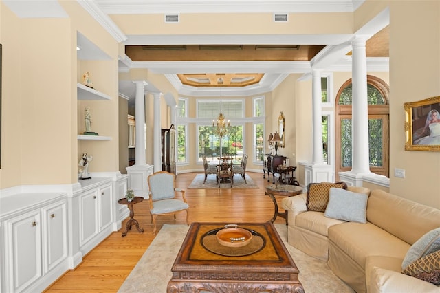 living room featuring ornamental molding, light hardwood / wood-style floors, ornate columns, and a chandelier