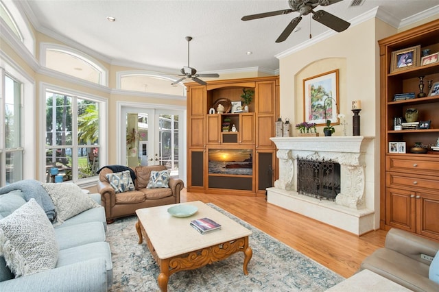 living room featuring a high end fireplace, crown molding, and ceiling fan