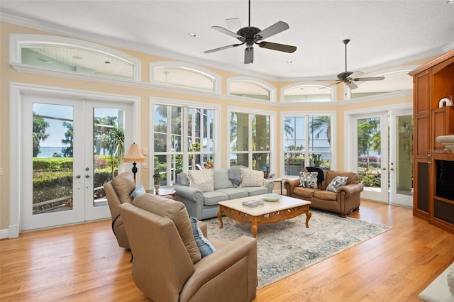 living room featuring light hardwood / wood-style flooring, french doors, ceiling fan, and ornamental molding