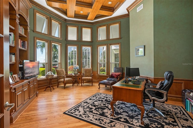 office space featuring a towering ceiling, light hardwood / wood-style flooring, crown molding, coffered ceiling, and beamed ceiling