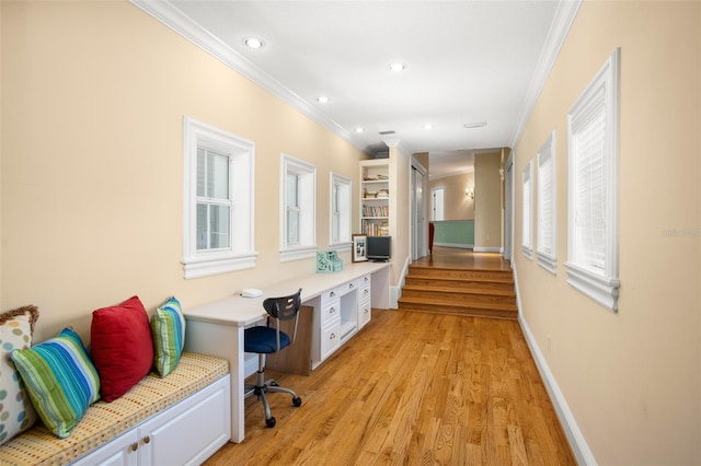 office space featuring a wealth of natural light, crown molding, and light wood-type flooring