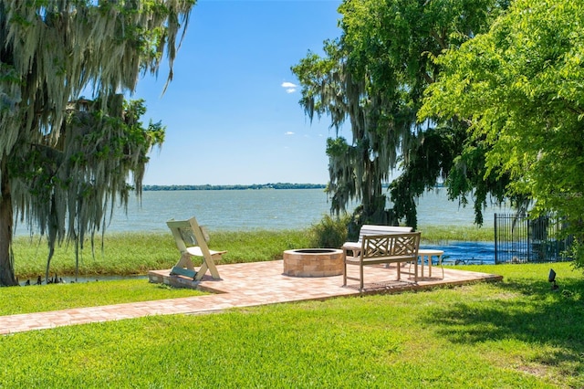 surrounding community featuring a patio area, an outdoor fire pit, a yard, and a water view