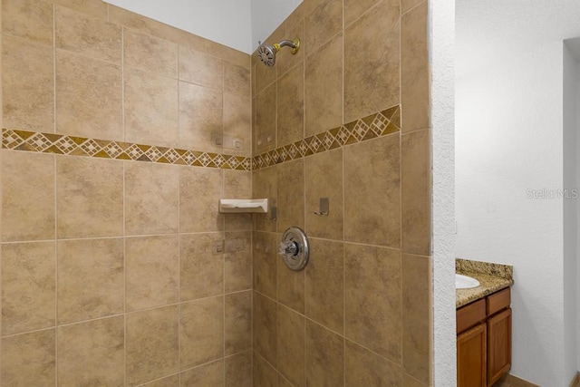 bathroom with vanity and tiled shower