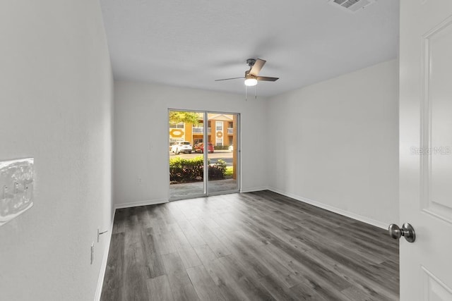 unfurnished room featuring dark wood-type flooring and ceiling fan