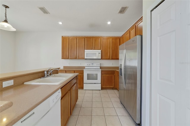 kitchen featuring decorative light fixtures, light stone counters, light tile floors, white appliances, and sink