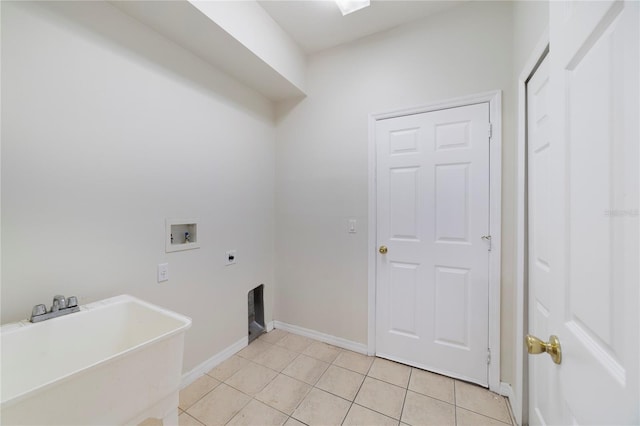 clothes washing area with electric dryer hookup, sink, light tile floors, and hookup for a washing machine