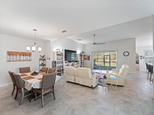 dining space with ceiling fan with notable chandelier, a textured ceiling, and light tile flooring