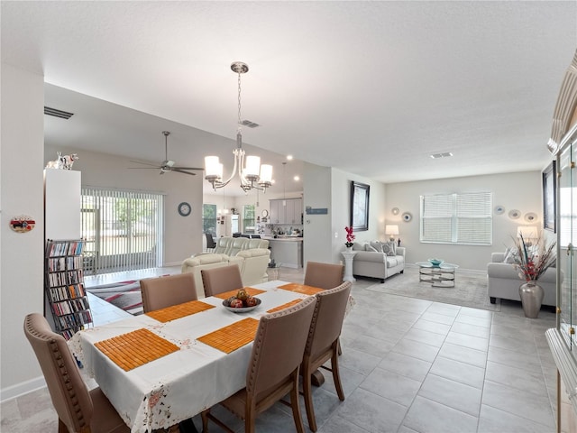 dining area featuring ceiling fan with notable chandelier and light tile flooring