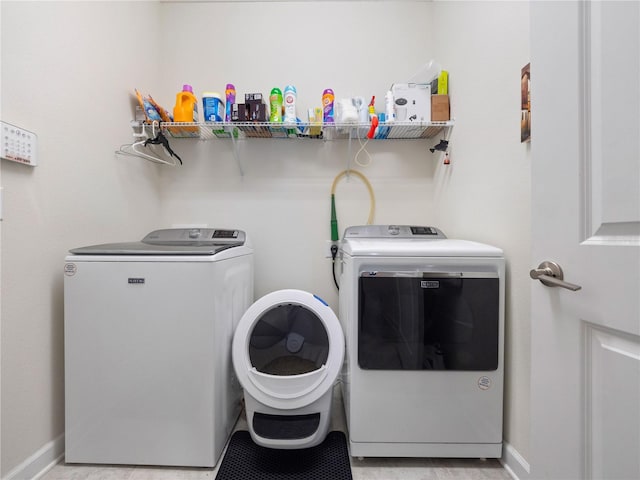 laundry room with light tile floors and separate washer and dryer