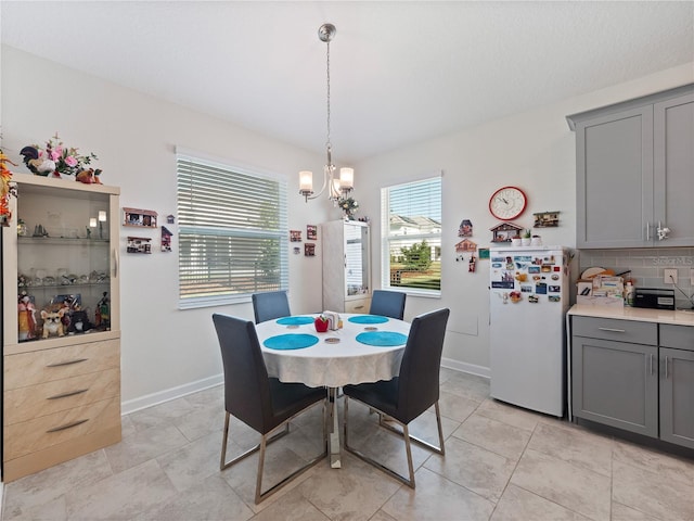 tiled dining area featuring an inviting chandelier