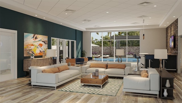 living room with a towering ceiling, french doors, plenty of natural light, and light hardwood / wood-style flooring