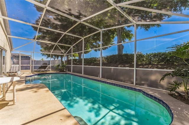 view of swimming pool featuring a patio and glass enclosure