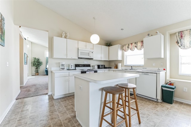 kitchen featuring light tile floors, white cabinets, white appliances, and vaulted ceiling