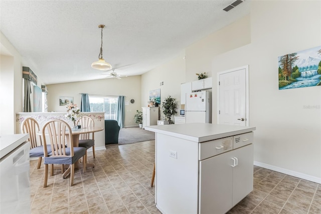 kitchen featuring white appliances, light tile floors, a kitchen island, ceiling fan, and lofted ceiling