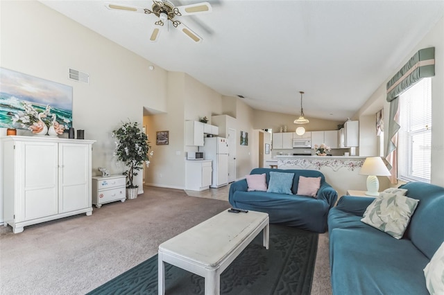 carpeted living room with ceiling fan and vaulted ceiling