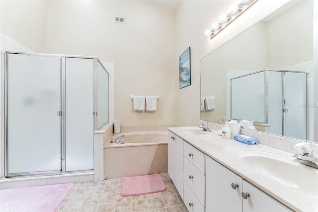 bathroom with tile flooring, separate shower and tub, and double sink vanity