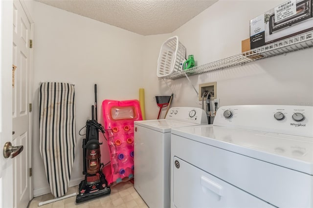 laundry area featuring washing machine and dryer, light tile floors, hookup for a washing machine, and a textured ceiling