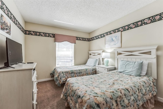 bedroom with dark colored carpet and a textured ceiling