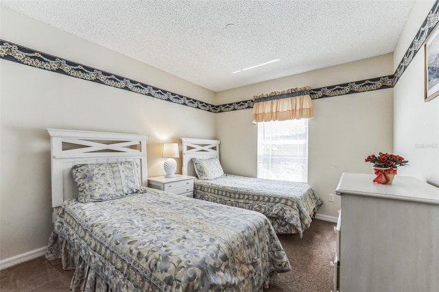 bedroom with dark colored carpet and a textured ceiling