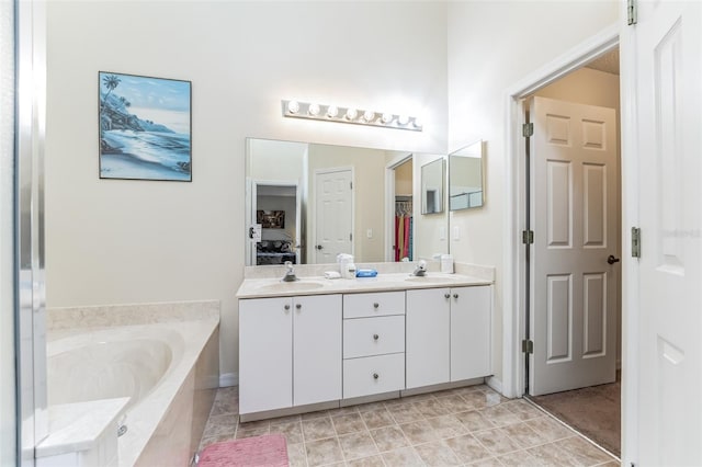 bathroom with dual sinks, tiled bath, tile flooring, and vanity with extensive cabinet space